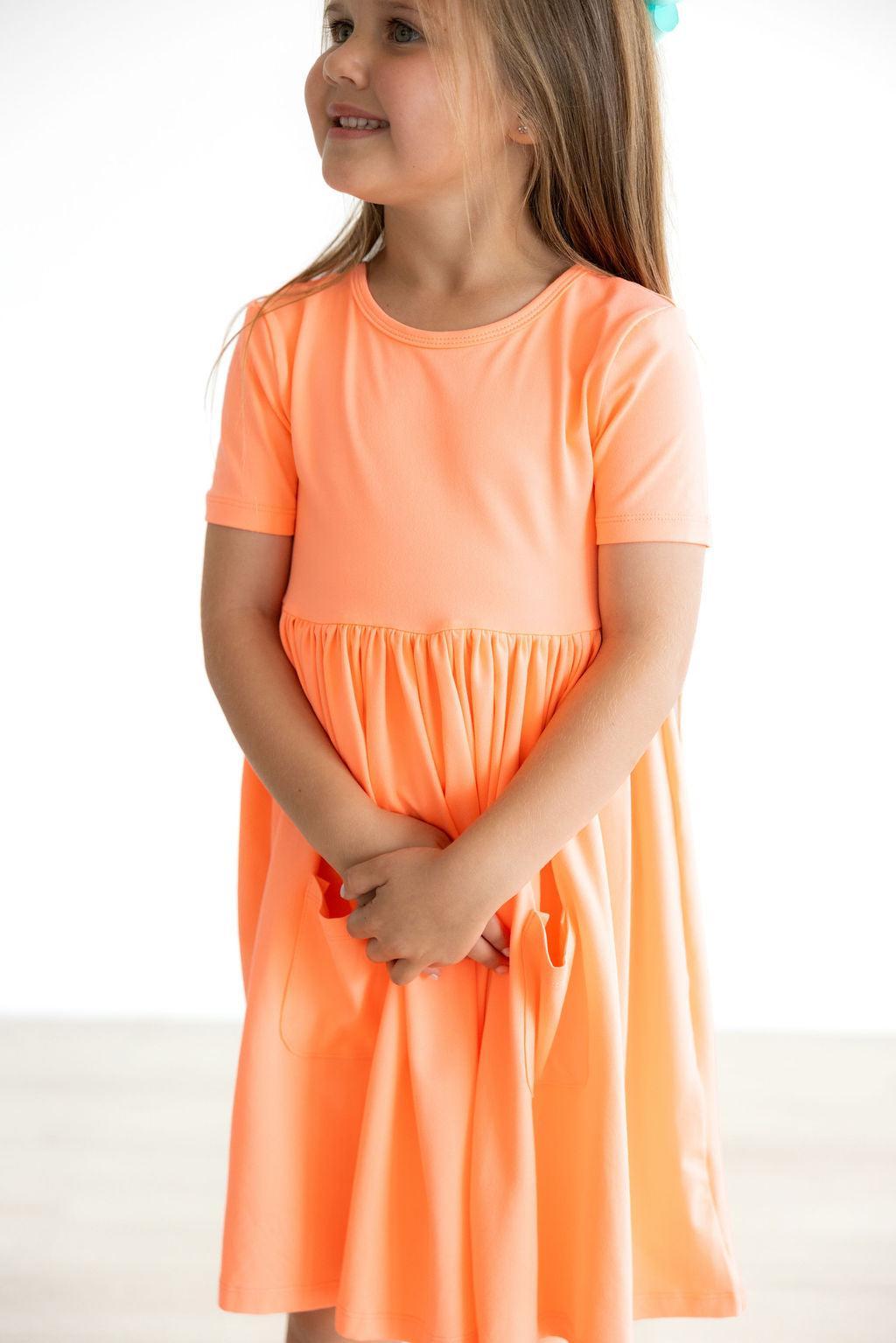 Robe virevoltante à poches corail fluo (manches courtes)